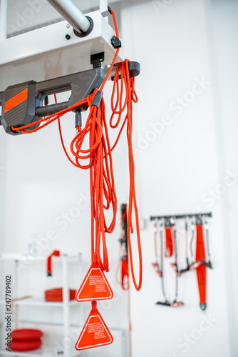 Red ropes and straps of the suspension medical equipment for spine treatment at the clinic