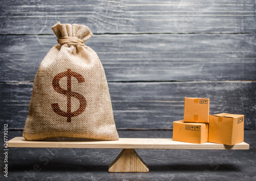 фотографія A bag of money and a bunch of boxes on the scales