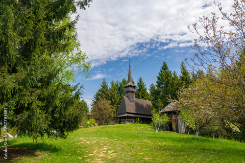 Scenic spring rural landscape with traditional maramures neo-gothic church, Maramures, Romania photo