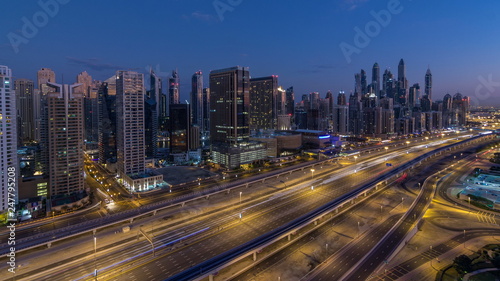 Dubai Marina skyscrapers aerial top view before sunrise from JLT in Dubai night to day timelapse, UAE.