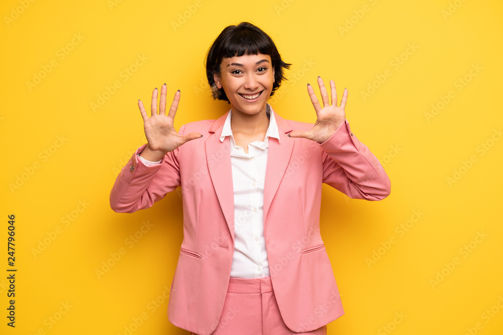Modern woman with pink business suit counting ten with fingers Modern woman with pink business suit counting ten with fingers
