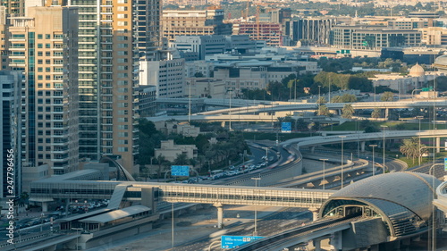 Futuristic building of Dubai metro and tram station and luxury skyscrapers behind timelapse