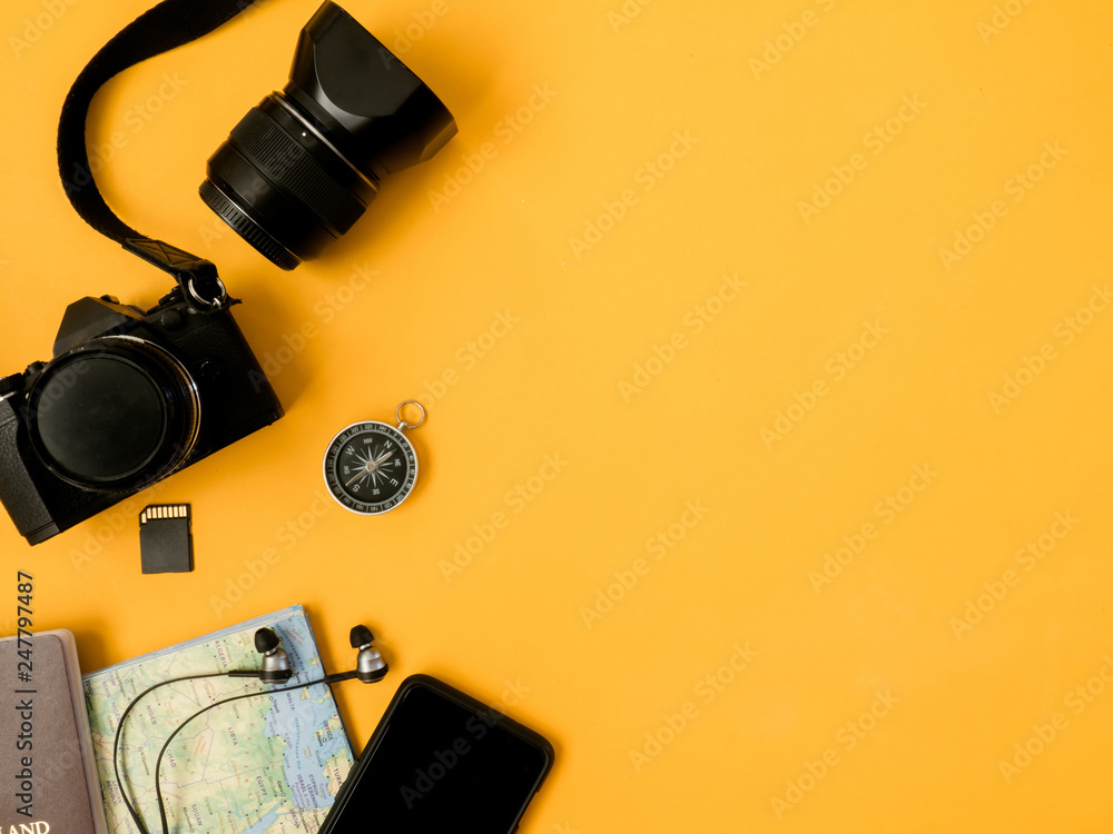 top view travel concept with camera, map, passport and travel accessories on yellow background, Tourist essentials, vintage tone effect top view travel concept with camera, map, passport and travel accessories on yellow background, Tourist essentials, vintage tone effect