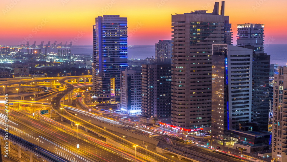 Dubai marina with traffic on sheikh zayed road panorama day to night timelapse lights turn on.