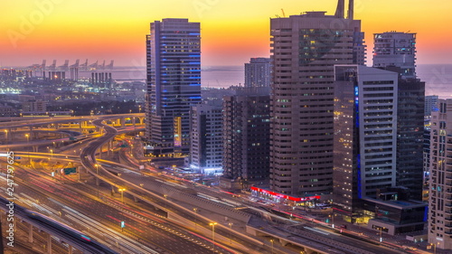 Dubai marina with traffic on sheikh zayed road panorama day to night timelapse lights turn on.