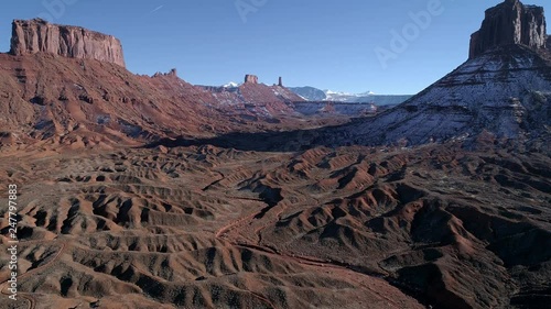 Aerial view flying over eroded desert towards Castleton Tower past Parriott Mesa in the old west desert terrain near Moab Utah. photo