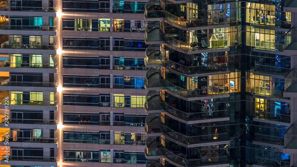 Glowing windows in multistory modern glass and metal residential building light up at night timelapse. Glowing windows in multistory modern glass and metal residential building light up at night timelapse.