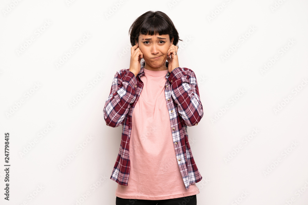 Young woman with short hair covering ears with hands. Frustrated expression Young woman with short hair covering ears with hands. Frustrated expression