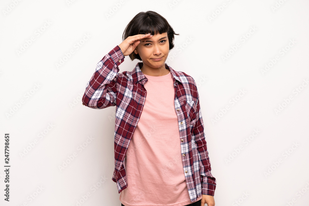 Young woman with short hair looking far away with hand to look something Young woman with short hair looking far away with hand to look something