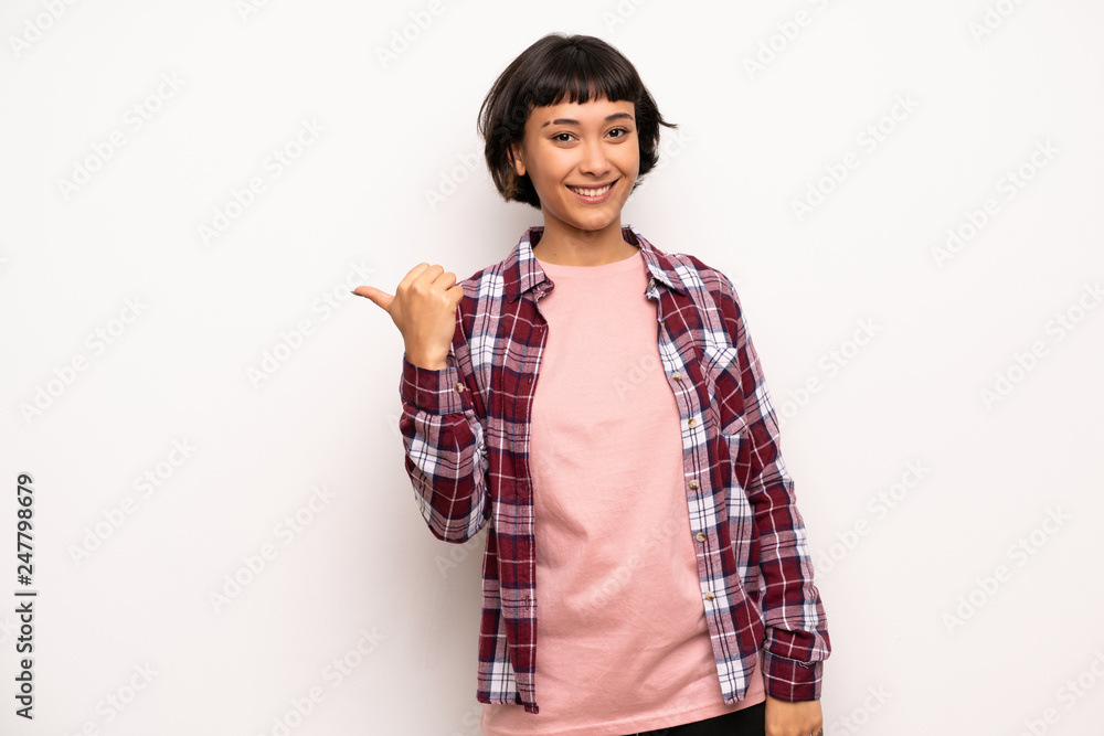 Young woman with short hair pointing to the side to present a product Young woman with short hair pointing to the side to present a product