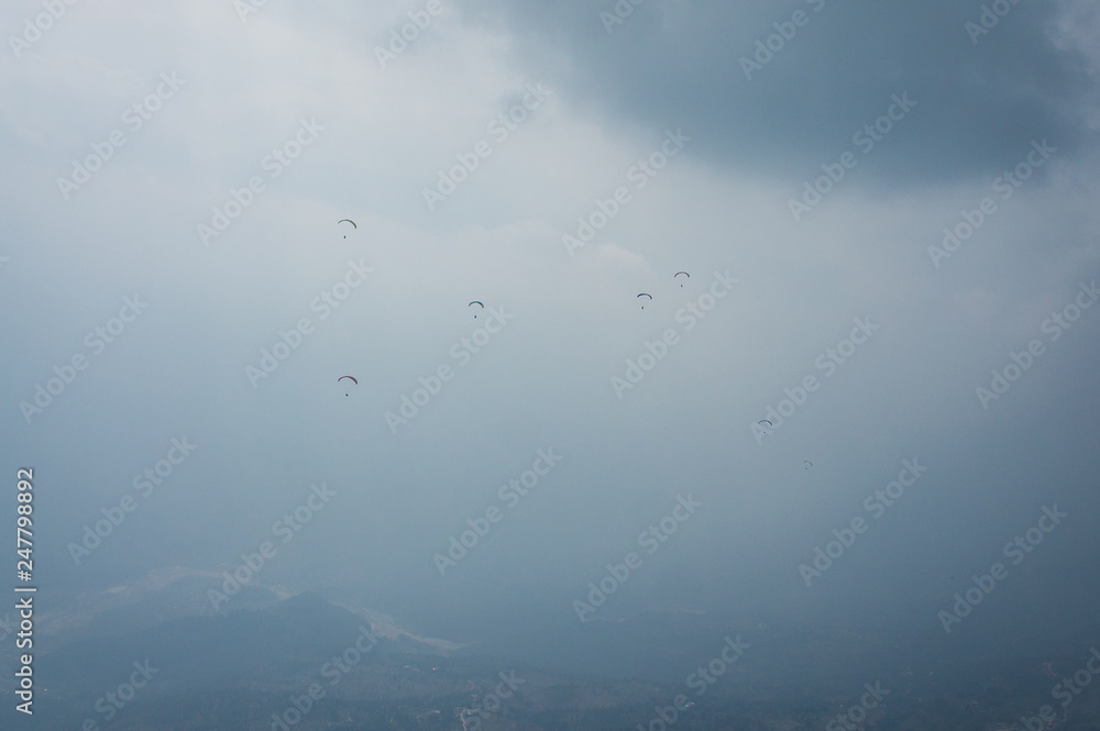 Paragliders in the sky. Flight in tandem with an instructor. Extreme sport. Pokhara Nepal 