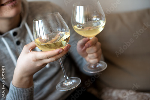 close up of hands with two white wine glasses