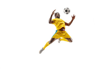 Professional african american football soccer player in motion isolated on white studio background. Fit jumping man in action, jump, movement at game.
