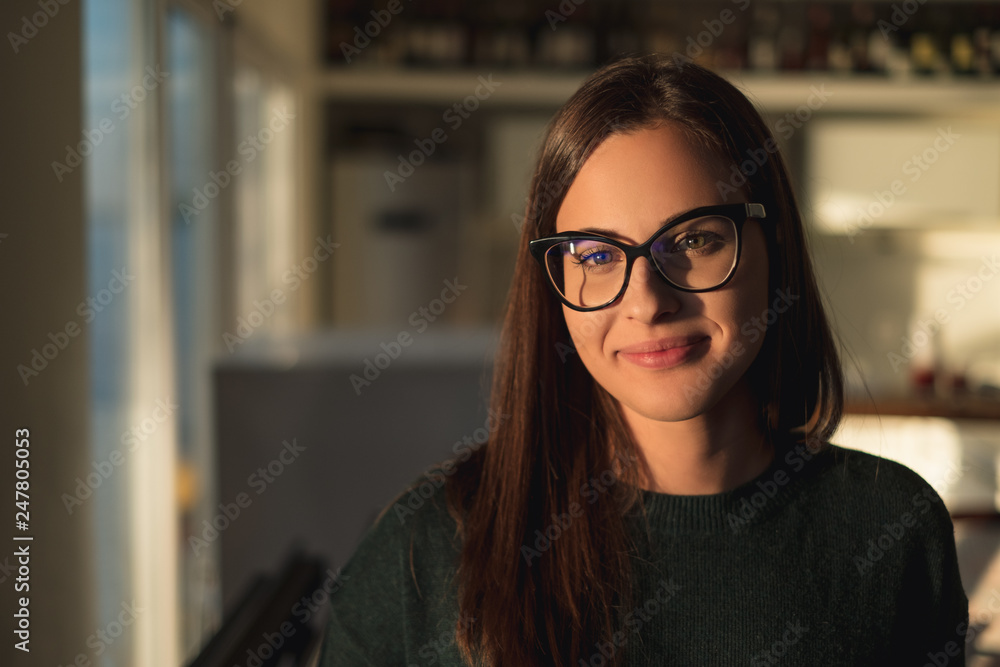 Beautiful girl with glasses smiling and standing by the window Beautiful girl with glasses smiling and standing by the window