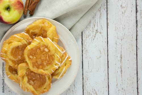 Obraz na plátně apple danish with linen napkin apple and cinnamon sticks on a plate and rustic w