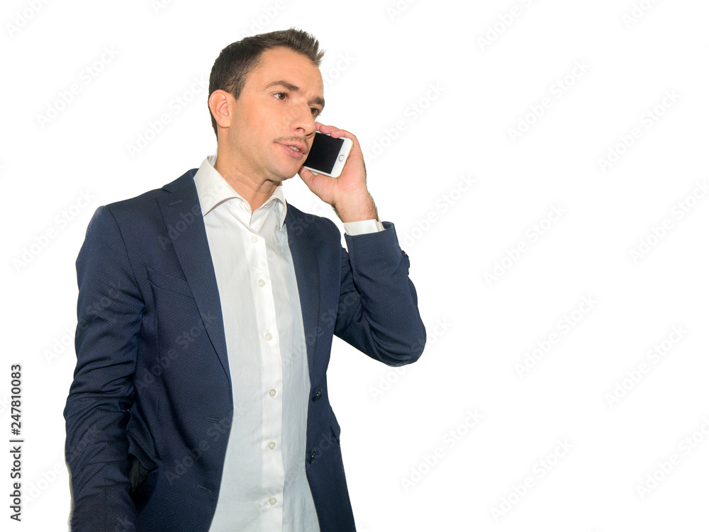 Confident man dressed in suit talking on mobile phone over white wall background Confident man dressed in suit talking on mobile phone over white wall background