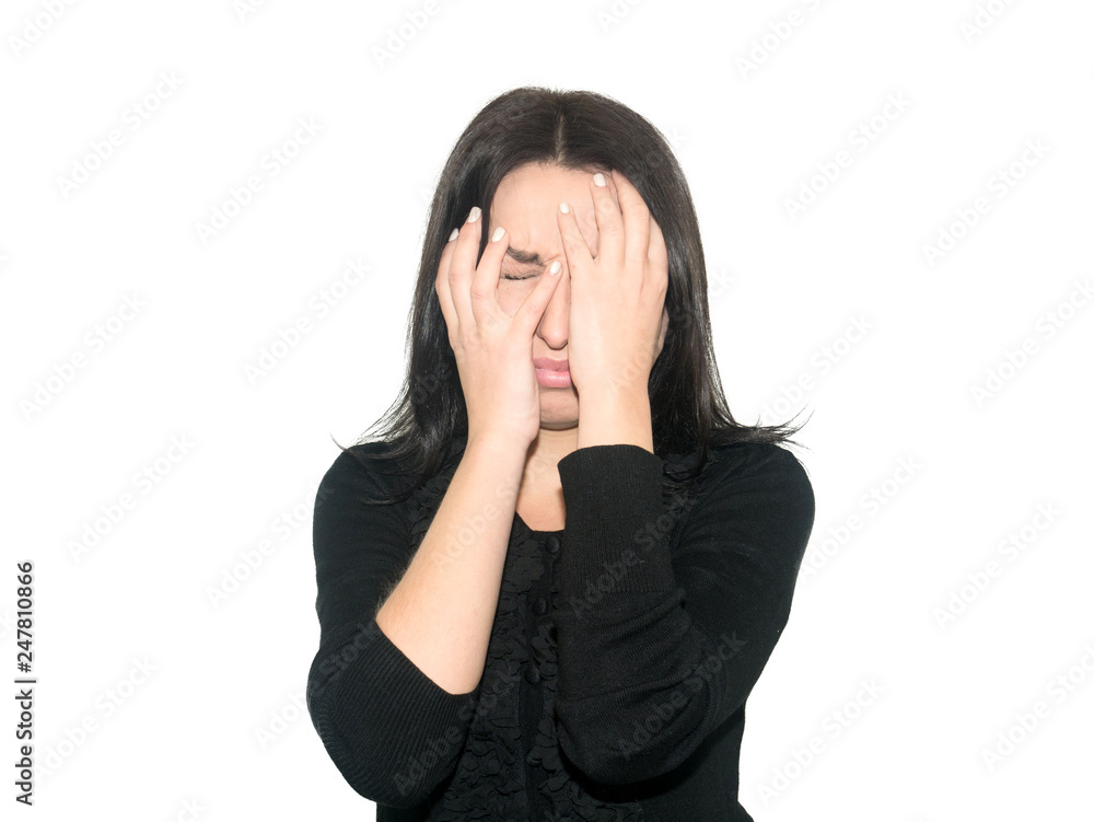The woman in dark clothes covered her face with hands. She feels great fear. Girl isolated on white background. The woman in dark clothes covered her face with hands. She feels great fear. Girl isolated on white background.