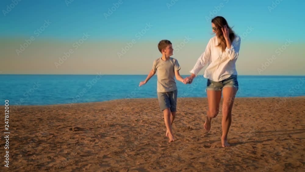 The mom and son run by the sea by the hand The mom and son run by the sea by the hand