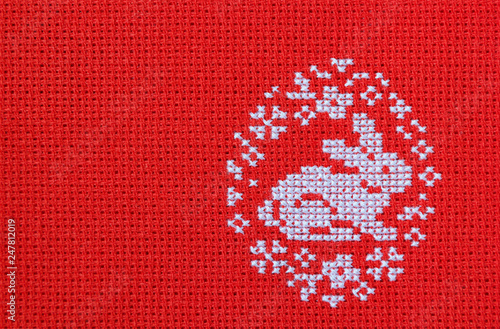 Easter rabbit embroidered on a red canvas.