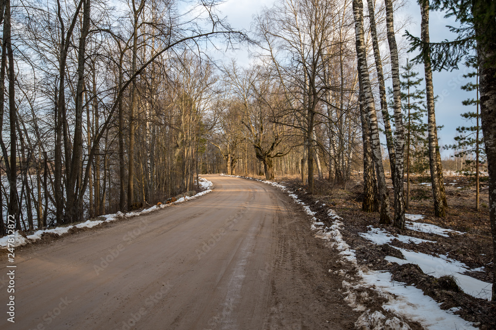 empty country gravel road with mud puddles and bumps empty country gravel road with mud puddles and bumps