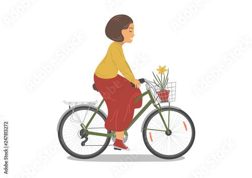 Fototapeta Naklejka Na Ścianę i Meble -  Cycling woman with daffodile flower in basket.