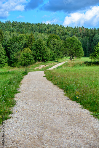 empty country gravel road with mud puddles and bumps