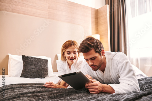 Ordering online service. Young man using tablet in hotel