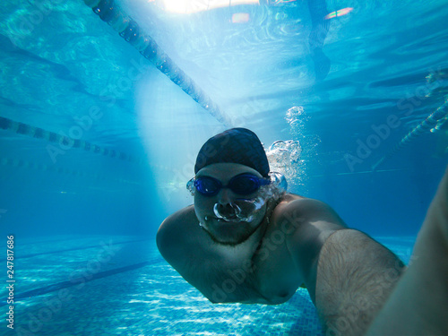 man underwater holding breath in pool