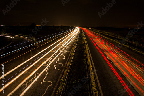 Headlights of cars, taken on highway with long-term exposure to the background of the sky