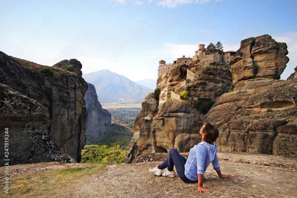 A tourist relaxes admiring the breathtaking view in Meteora