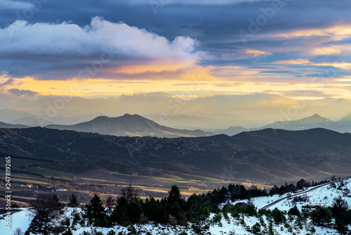 Nice landscape with mountains, snow and clouds at sunrise