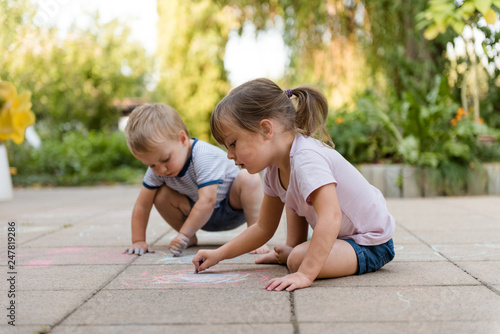 Children drawing with chalk in backyard photo