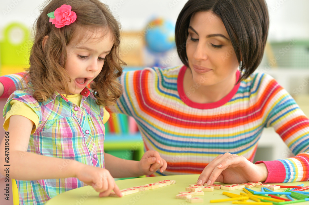 Fototapeta premium Portrait of young mother playing with little daughter