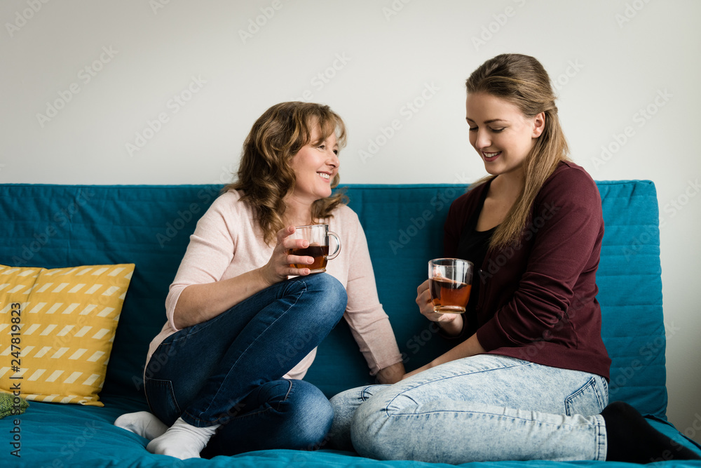 Women sitting in living room, gossiping and having tea. Women sitting in living room, gossiping and having tea.