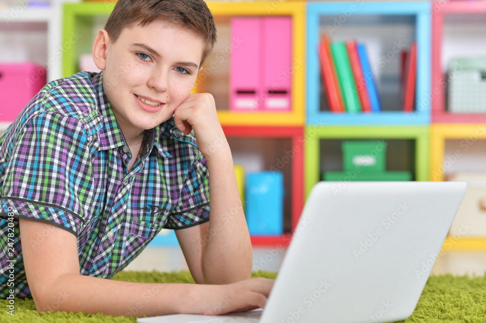 Portrait of boy using laptop while lying on floor Portrait of boy using laptop while lying on floor