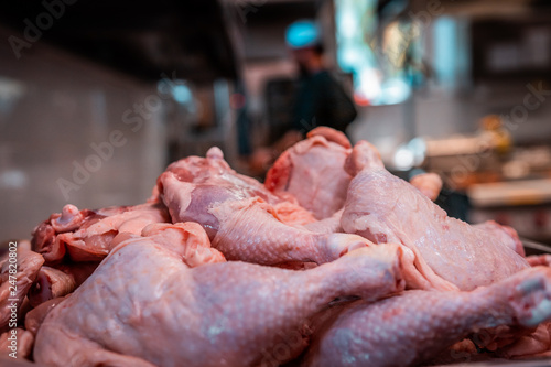 Raw chicken chops stacked and ready for preparation. Restaurant life, industrial food chain, uncooked proteins, close up of wings and breasts on a stainless steel tray