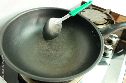 Tableau sur toile Scratches on the teflon frying pan with Stainless Steel Turner on the gas stove,