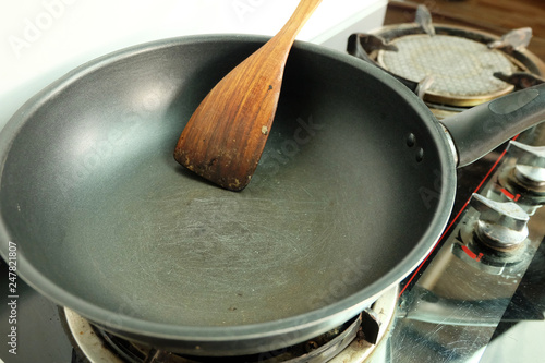 Scratches on the teflon frying pan with spatula on the gas stove, Sloppy kitchen photo