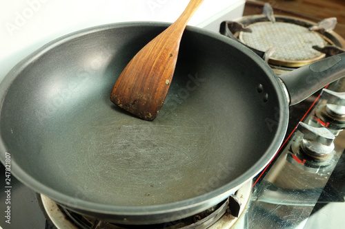 Photos Scratches on the teflon frying pan with spatula on the gas stove, Sloppy kitchen