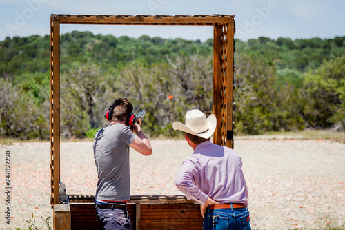 Shooting clay pigeons in Texas USA, watched by a real cowboy