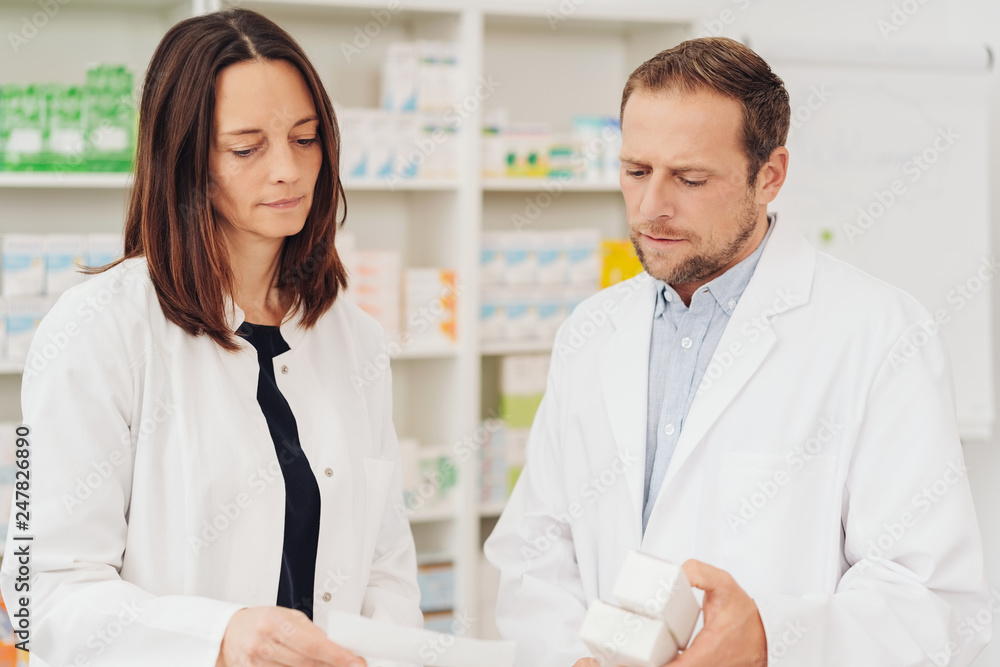 Two concerned pharmacists discussing a script Two concerned pharmacists discussing a script