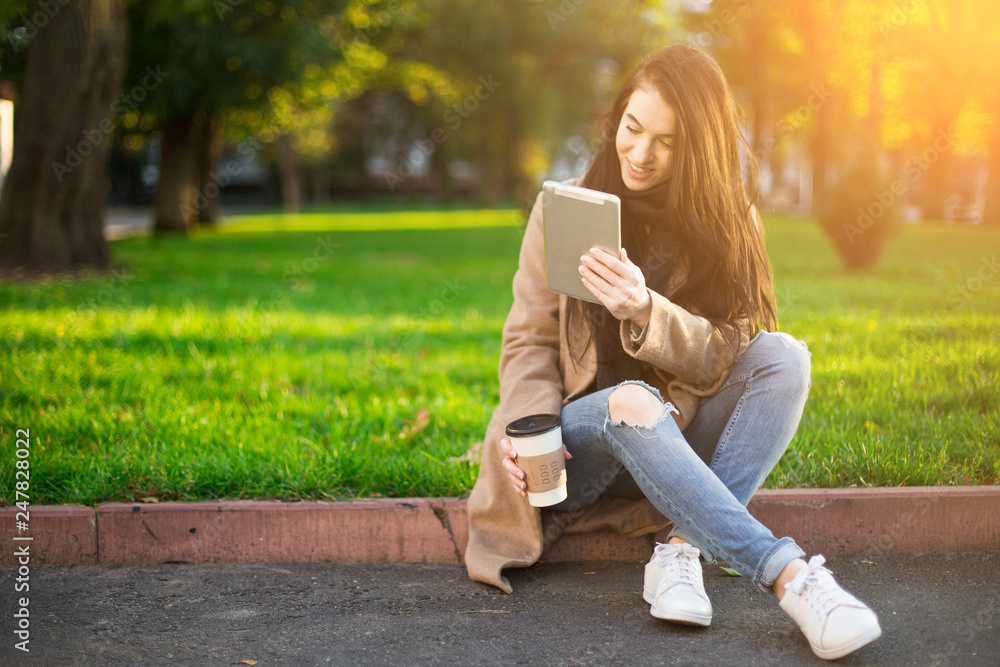 young trendy woman in autumn city park with smartphone in hand young trendy woman in autumn city park with smartphone in hand
