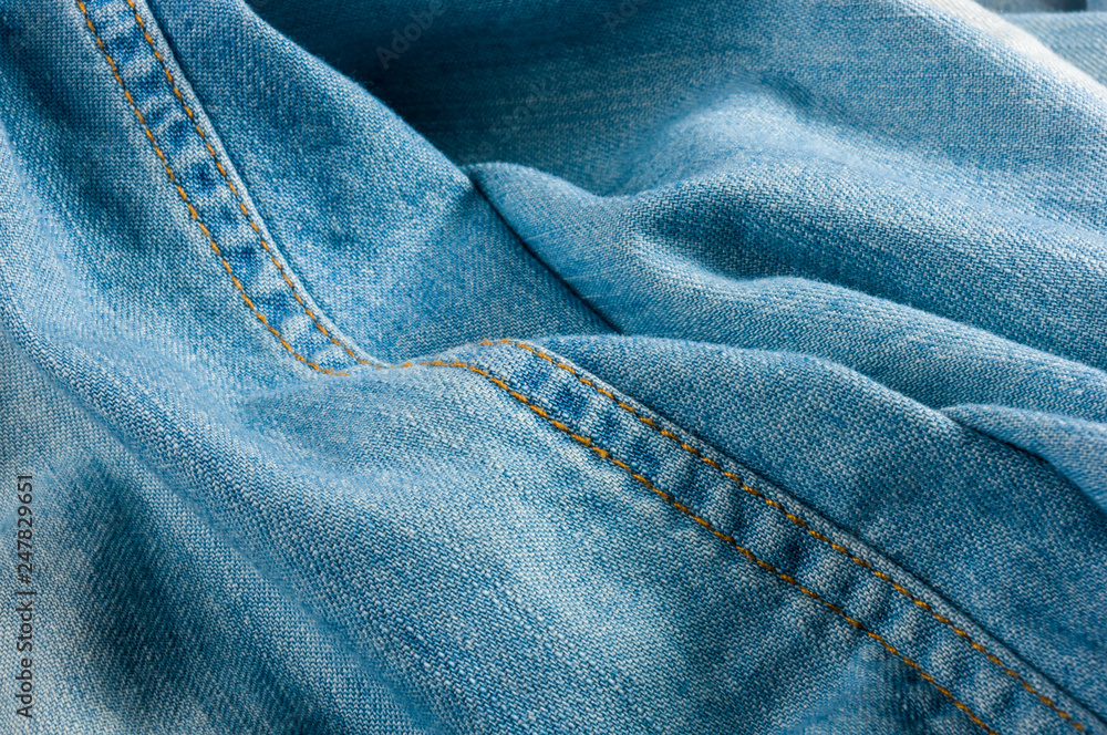 Fototapeta premium Blue washed faded jeans texture with seams