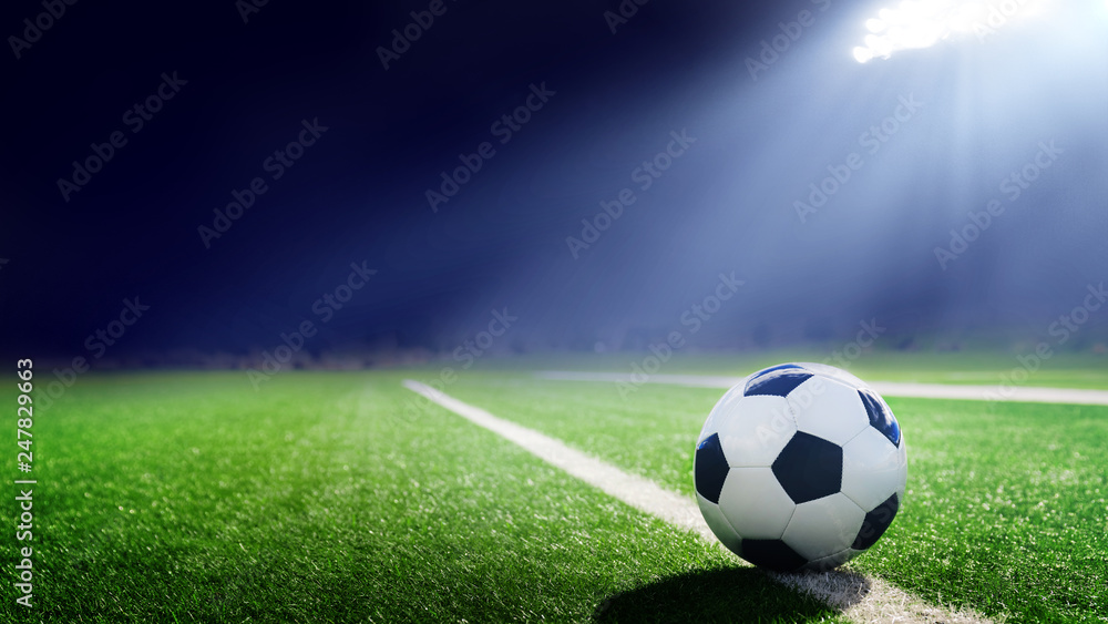 Tradition soccer ball illuminated by stadium lights - obrazy, fototapety, plakaty 