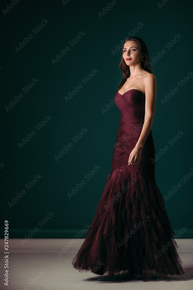 gorgeous fashion woman in evening dress posing over dark green background gorgeous fashion woman in evening dress posing over dark green background