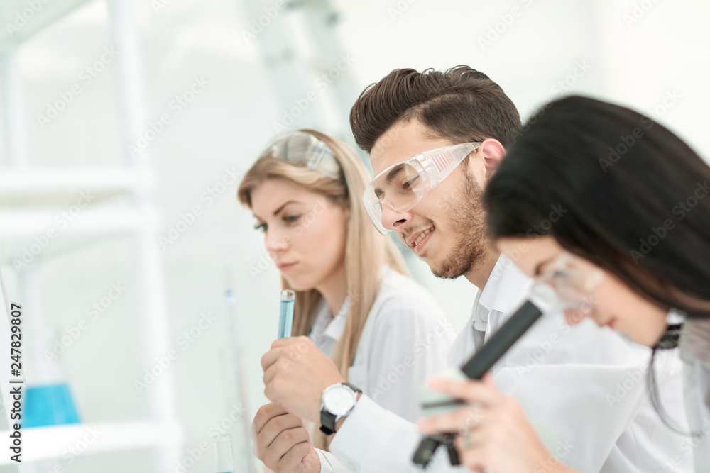 close up.a group of young scientists conduct experiments in the laboratory. close up.a group of young scientists conduct experiments in the laboratory.