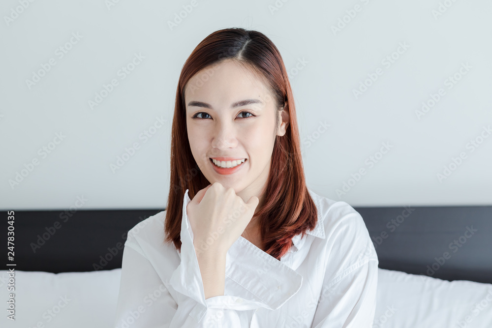 beautiful woman wear white shirt smile in bed room at the morning beautiful woman wear white shirt smile in bed room at the morning