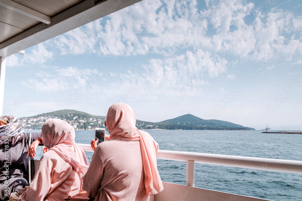 Women in pink shawls at sea walk