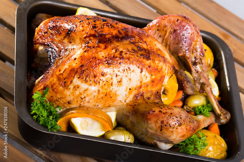 Close up of tasty baked turkey with apples, lemon and herbs