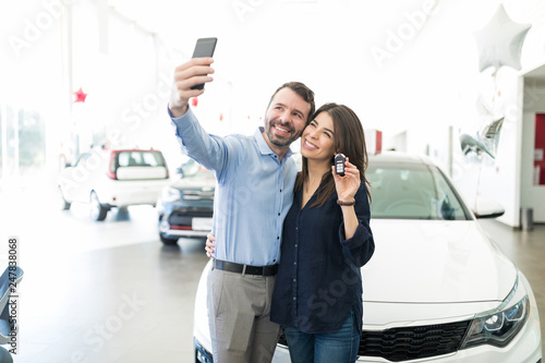 Man And Woman Taking Selfie With Luxury Car photo